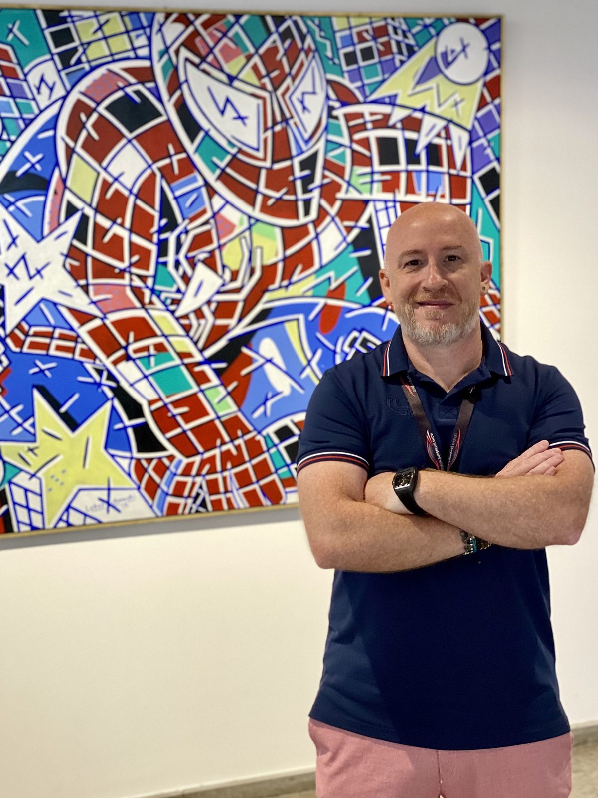 Gabriele Rossicarri von Veltracon Lifestyle vor einem expressionistischen Gemälde von Rolf Lukaschewski auf der Geneva Supercar Show 2024