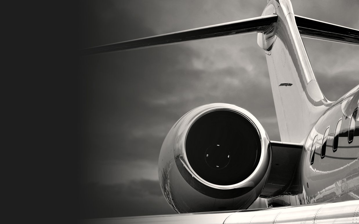 A private jet engine against a bright sky