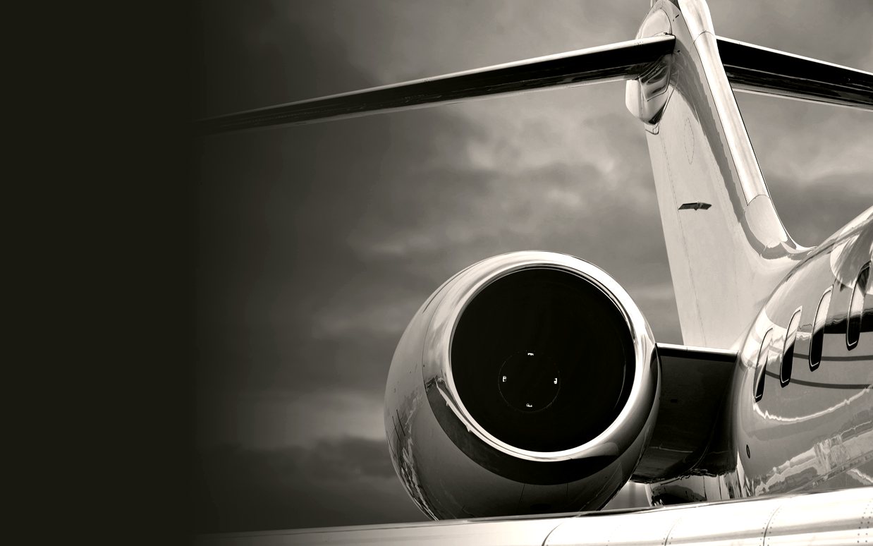 A private jet engine against a bright sky